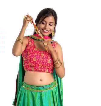 Beautiful girl showing Rakhi on occasion of Raksha bandhan on a white background. Sister tie Rakhi as symbol of intense love for her brother. photo