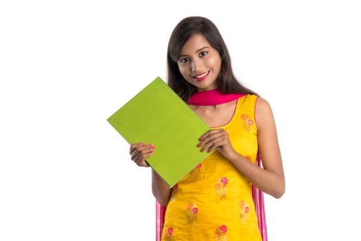 Pretty young girl holding book and posing on white background photo