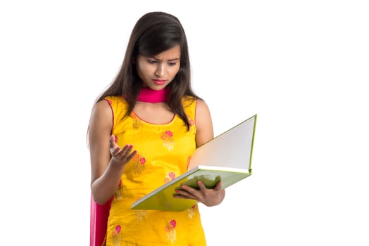 Pretty young girl holding book and posing on white background photo