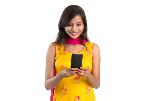 Young Indian girl using a mobile phone or smartphone isolated on a white background photo