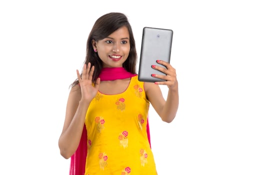 Young Indian girl using a Tablet, mobile phone or smartphone isolated on a white background photo