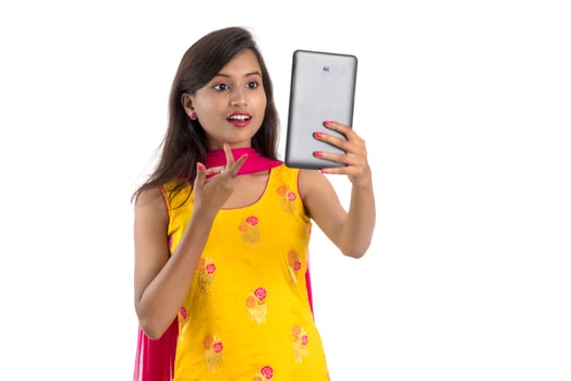 Young Indian girl using a Tablet, mobile phone or smartphone isolated on a white background photo