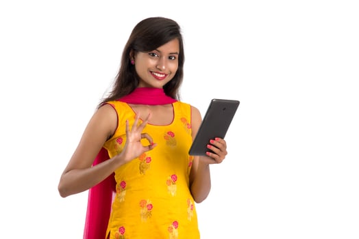 Young Indian girl using a mobile phone or smartphone isolated on a white background photo