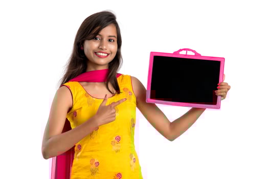 Beautiful young girl holding and showing something on a chalkboard or slate, isolated over white background photo