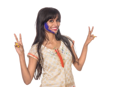 Beautiful young girl posing with colorful face in the occasion of Holi festival on white background. photo