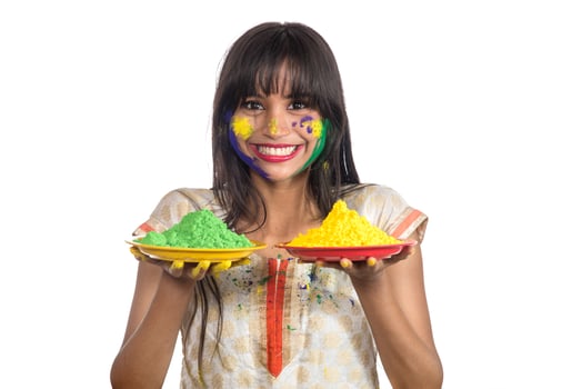 Beautiful young girl holding powdered color in plate on the occasion of Holi festival. photo