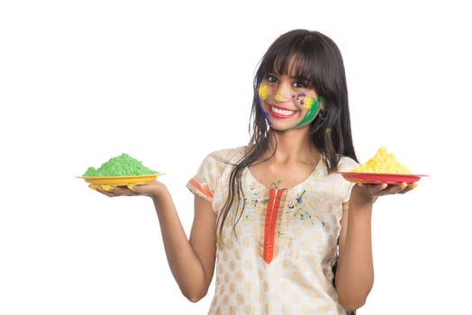 Beautiful young girl holding powdered color in plate on the occasion of Holi festival. photo
