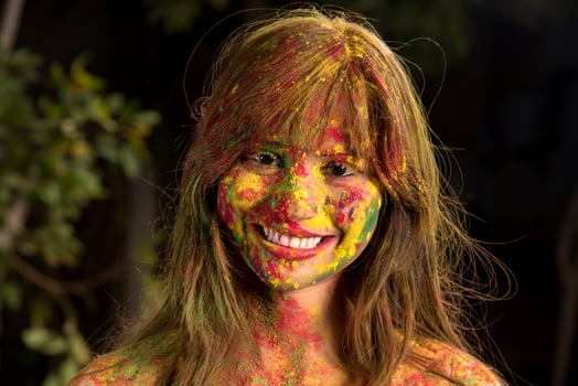 Portrait of a happy young girl on the festival of colors Holi. Girl posing and celebrating the festival of colors. photo