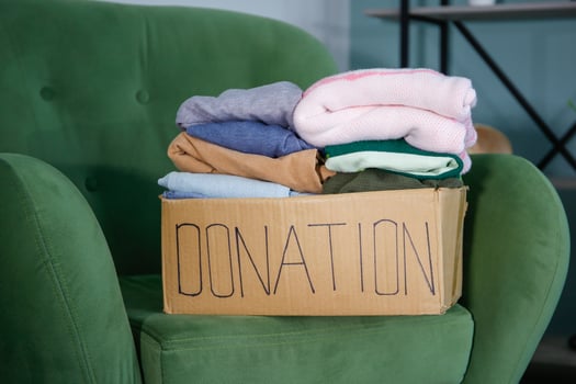 Donation box with clothes on the armchair in the living room. photo