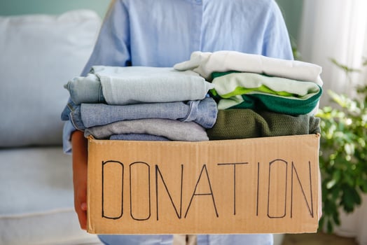 Girl holding donation box with with clothes. photo
