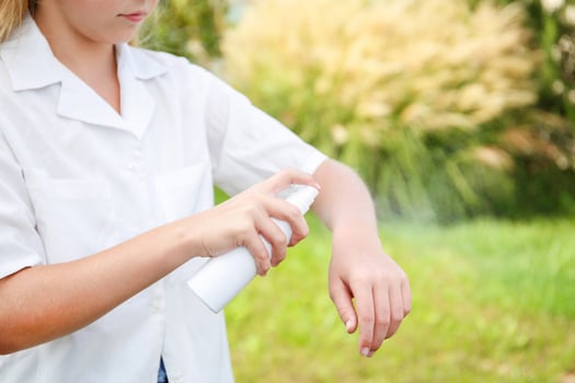 A teenager applies insect spray on his hand. The concept of prevention from mosquito bite. photo