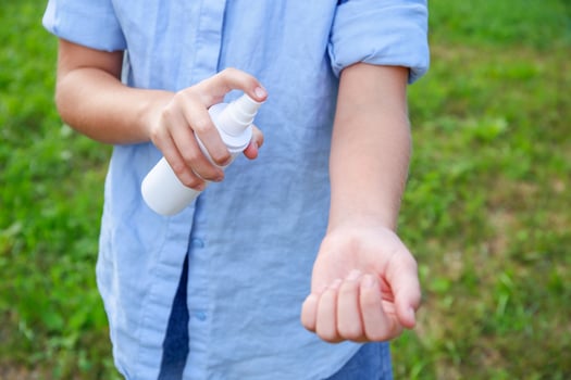 A teenager applies insect spray on his hand. The concept of prevention from mosquito bite. photo