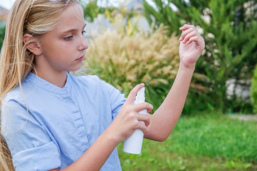 A teenager applies insect spray on his hand. The concept of prevention from mosquito bite. photo