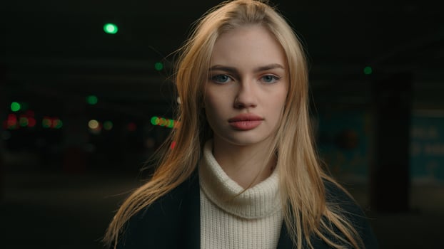 Portrait serious Caucasian 30s woman businesswoman driver car owner posing on darkness background female entrepreneur lady looking front at camera standing in underground car parking alone lonely girl photo
