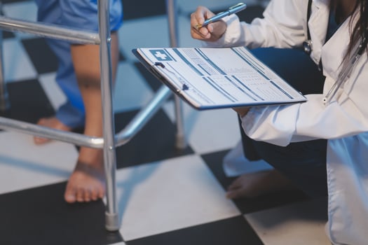 A doctor is writing on a clipboard photo