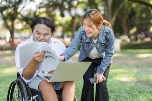 Young Professional in Wheelchair Collaborating with Colleagues Outdoors in a Modern Work Environment photo