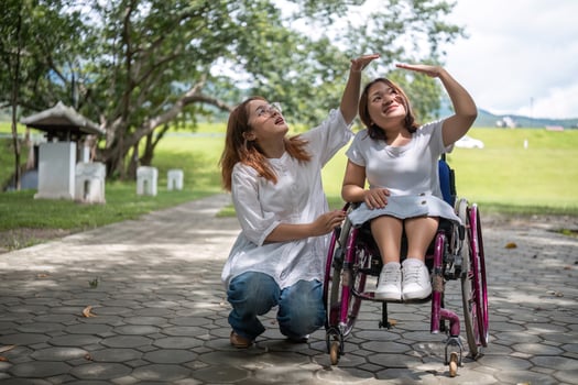 Young Woman in Wheelchair Enjoying a Walk in the Park with Her Best Friend on a Sunny Day photo
