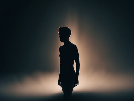 Silhouette of a performer on stage under bright stage lights at night. photo