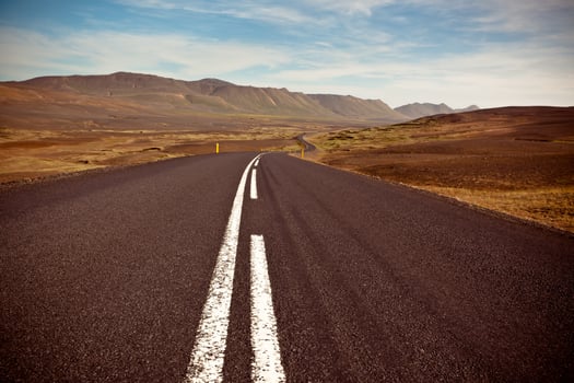 Highway through dry gravel lava field landscape under a blue summer sky photo