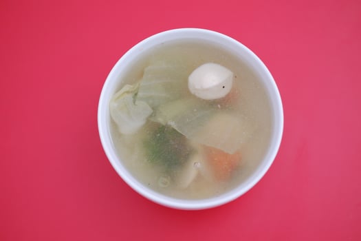 A bowl of soup on a red table photo