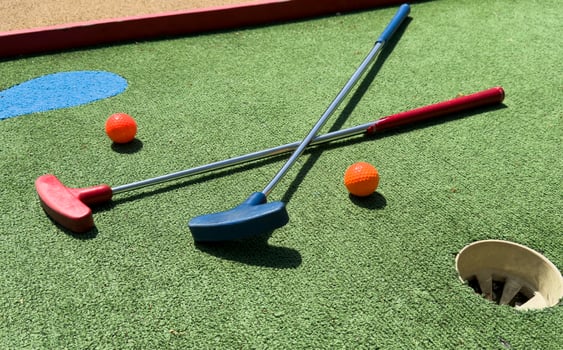 Golf stick and ball on green grass close up. photo