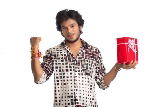 Man or Brother showing rakhi on his hand with shopping bags and gift box on the occasion of Raksha Bandhan festival. photo