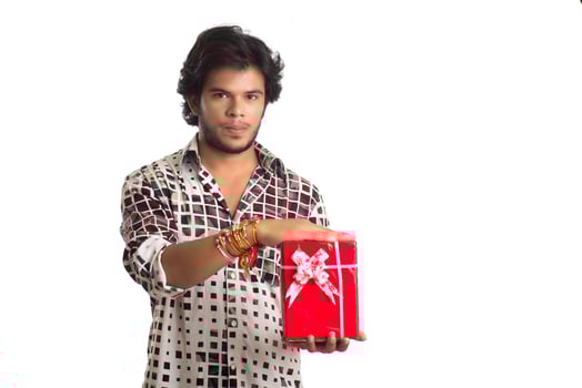 Man or Brother showing rakhi on his hand with shopping bags and gift box on the occasion of Raksha Bandhan festival. photo