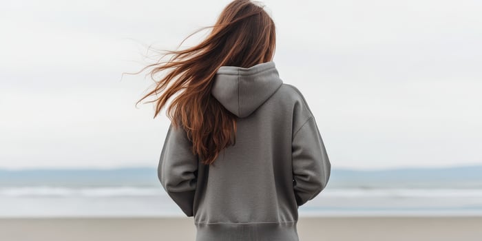 Young woman enjoys a quiet moment by the beach on a cloudy day photo