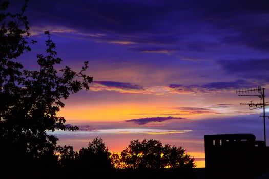 A beautiful house stands silhouetted against a stunning sunset sky photo