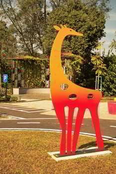 A park with vibrant metal giraffe sculptures painted in gradient colors stands out against the greenery in Taman Tasik Puteri Ijok. photo
