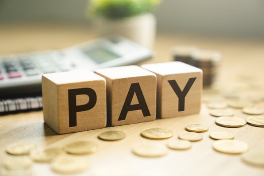 Wooden blocks spelling PAY placed on a desk with coins, calculator, and notebook, symbolizing salary payment, financial transaction, payroll, budgeting, and business expense management photo