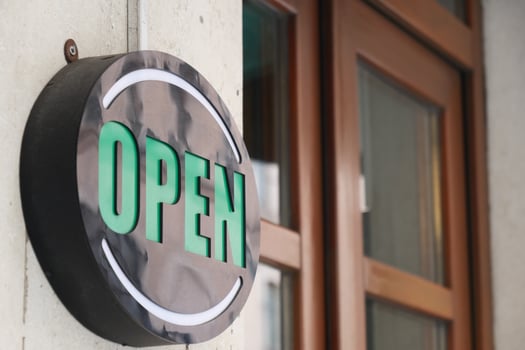 An Illuminated Open Sign is hanging prominently at the entrance of the store, welcoming customers photo