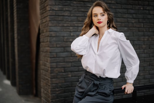 Elegant businesswoman posing near brick wall in urban setting photo