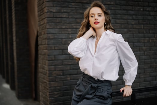 Elegant businesswoman posing with hand on neck in urban setting photo