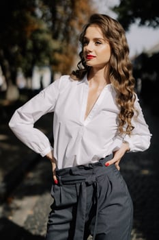 Businesswoman posing with hands on hips in city park photo