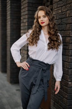 Elegant businesswoman posing near brick wall in urban setting photo