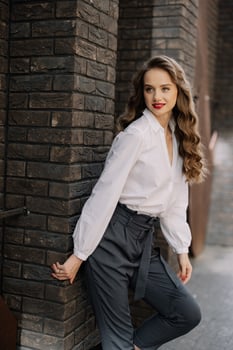 Elegant businesswoman leaning against brick wall in urban setting photo
