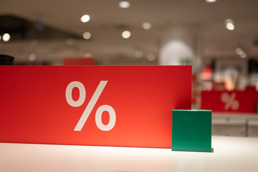 Red-coloured sales sign displaying percentage discounts. photo