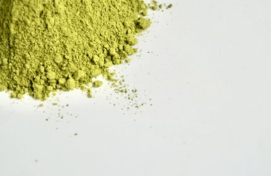 Matcha powder or finely grounded green tea isolated on horizontal empty copy spaced white background. photo