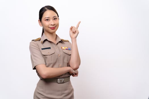 Young Thai Asian Teacher in the uniform is pointing to the empty copy space. photo