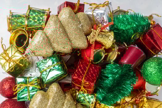 Pile of colorful Christmas decorations with shiny ornaments and gifts, top view photo