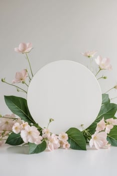 White oval frame with pink flowers and leaves on a white background photo