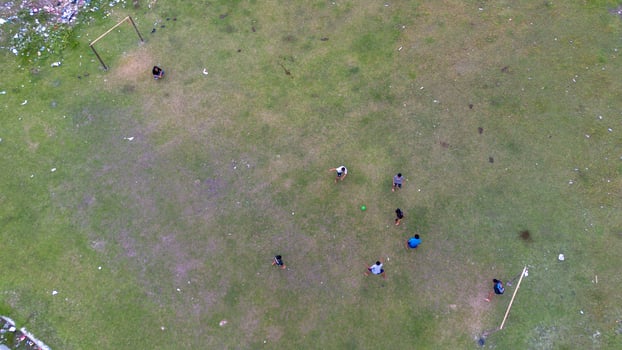 Aerial view of people playing soccer on green grass field in public park photo