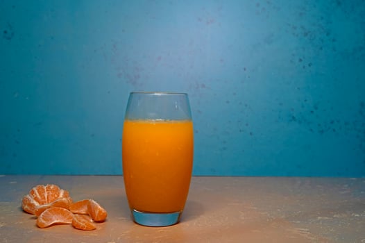 Sliced tangerines and a glass of juice on the table. photo