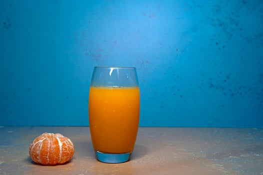 Peeled tangerines and a glass of juice on the table. photo