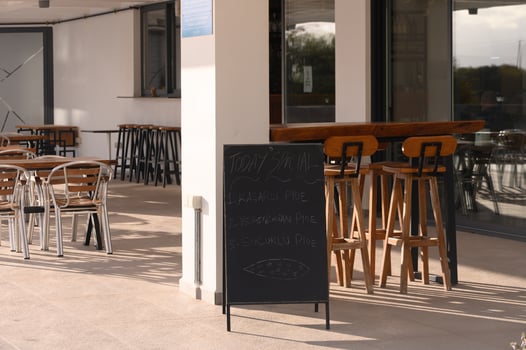 Enjoying a sunny afternoon at a cozy cafe with wooden furniture and a chalkboard menu photo