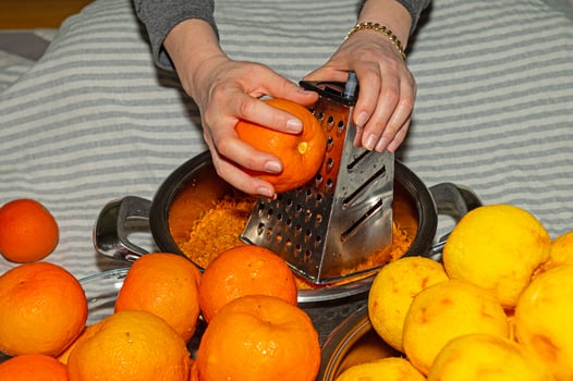 The woman grates the rind of citrus fruits to make jam. photo