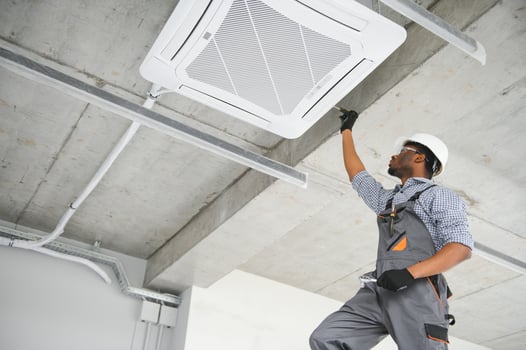 Professional repairman installing air conditioner in a room photo