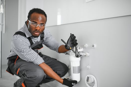 African american plumber change the water filter. photo
