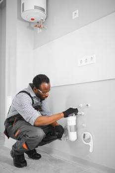 African american plumber change the water filter. photo